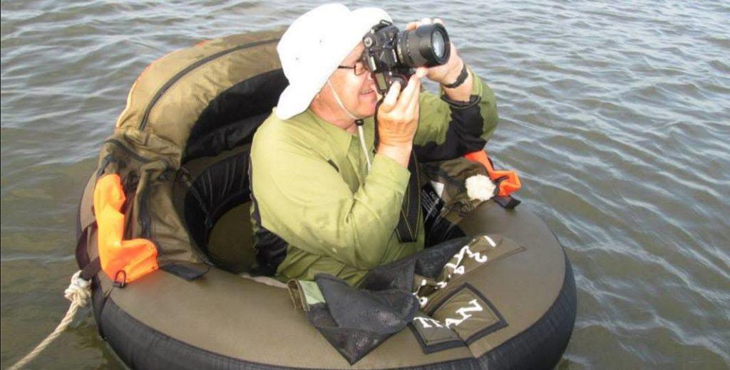 John Phillips taking photos at a lake.