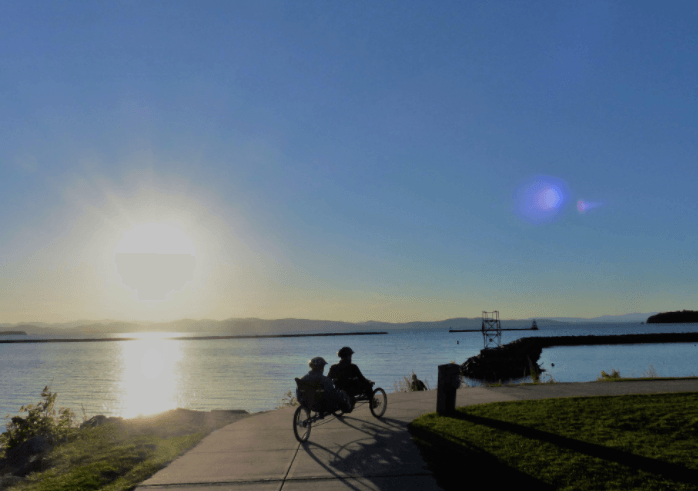 Adaptive cyclists at sunset beside a lake