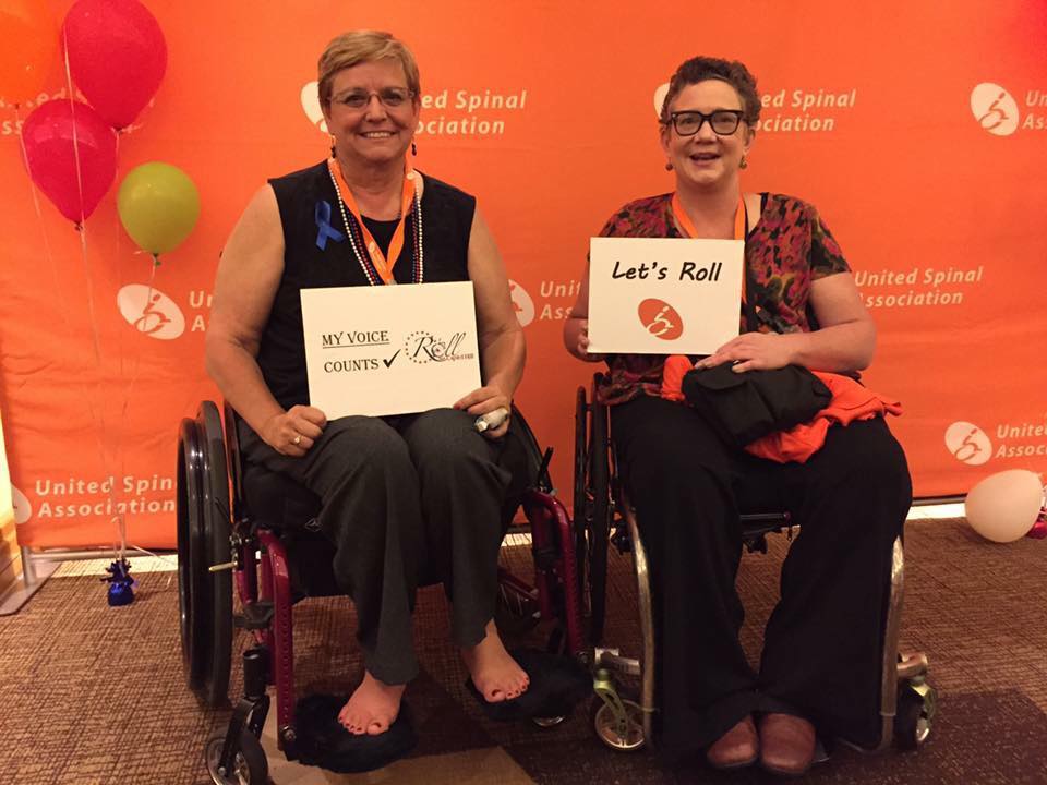 women in wheelchairs pose at united spinal event