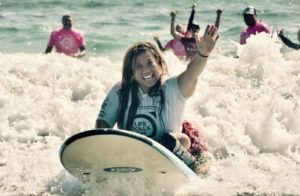 a woman happy doing adaptive surfing