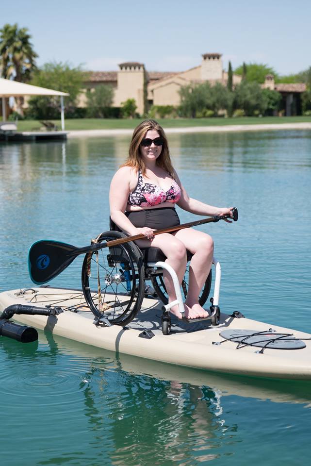 a woman in a wheelchair on a paddle board