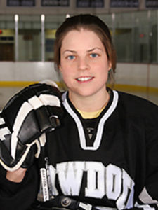 Kristen in a Bowdoin hockey jersey, holding a hockey stick
