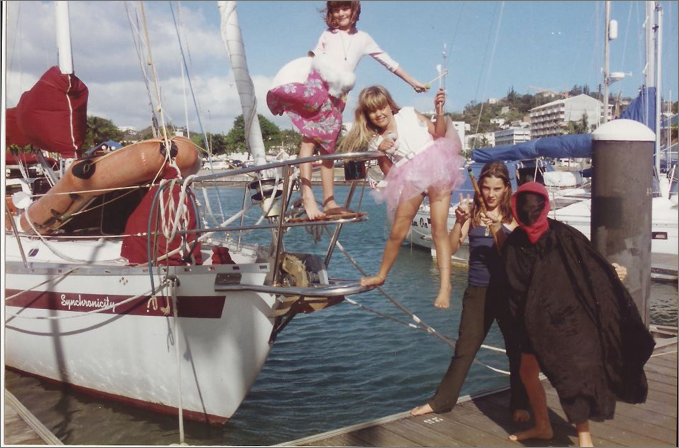 Children playing on a sail boat named synchronicity