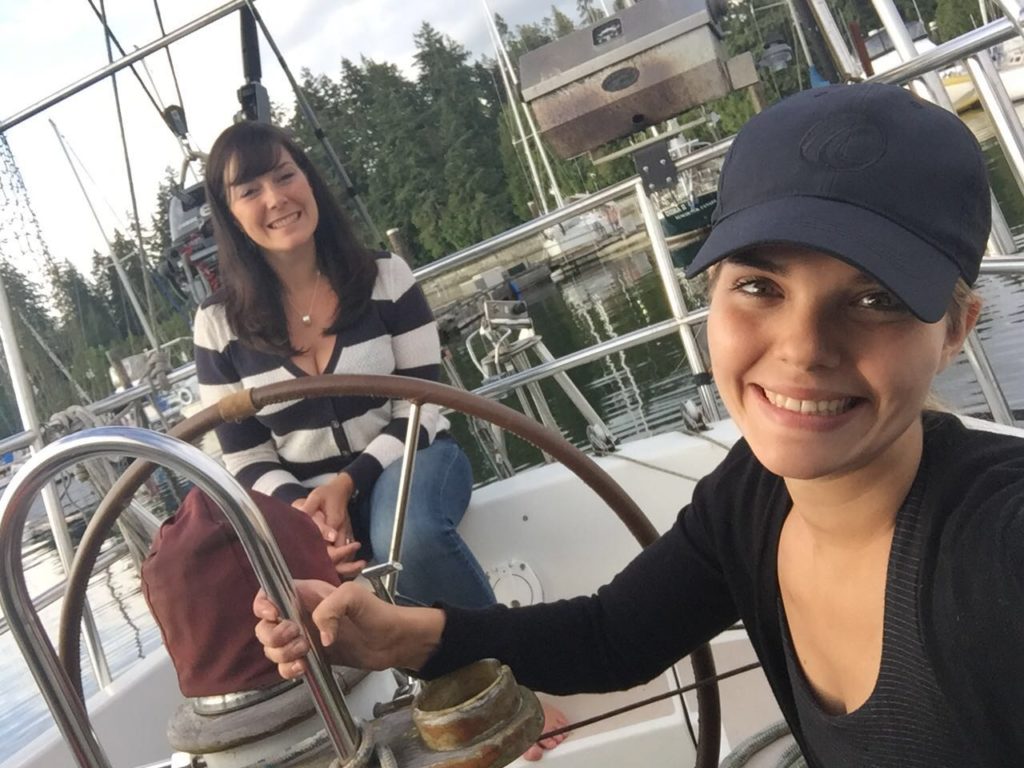 Jessica sitting with friend on board of a sailboat